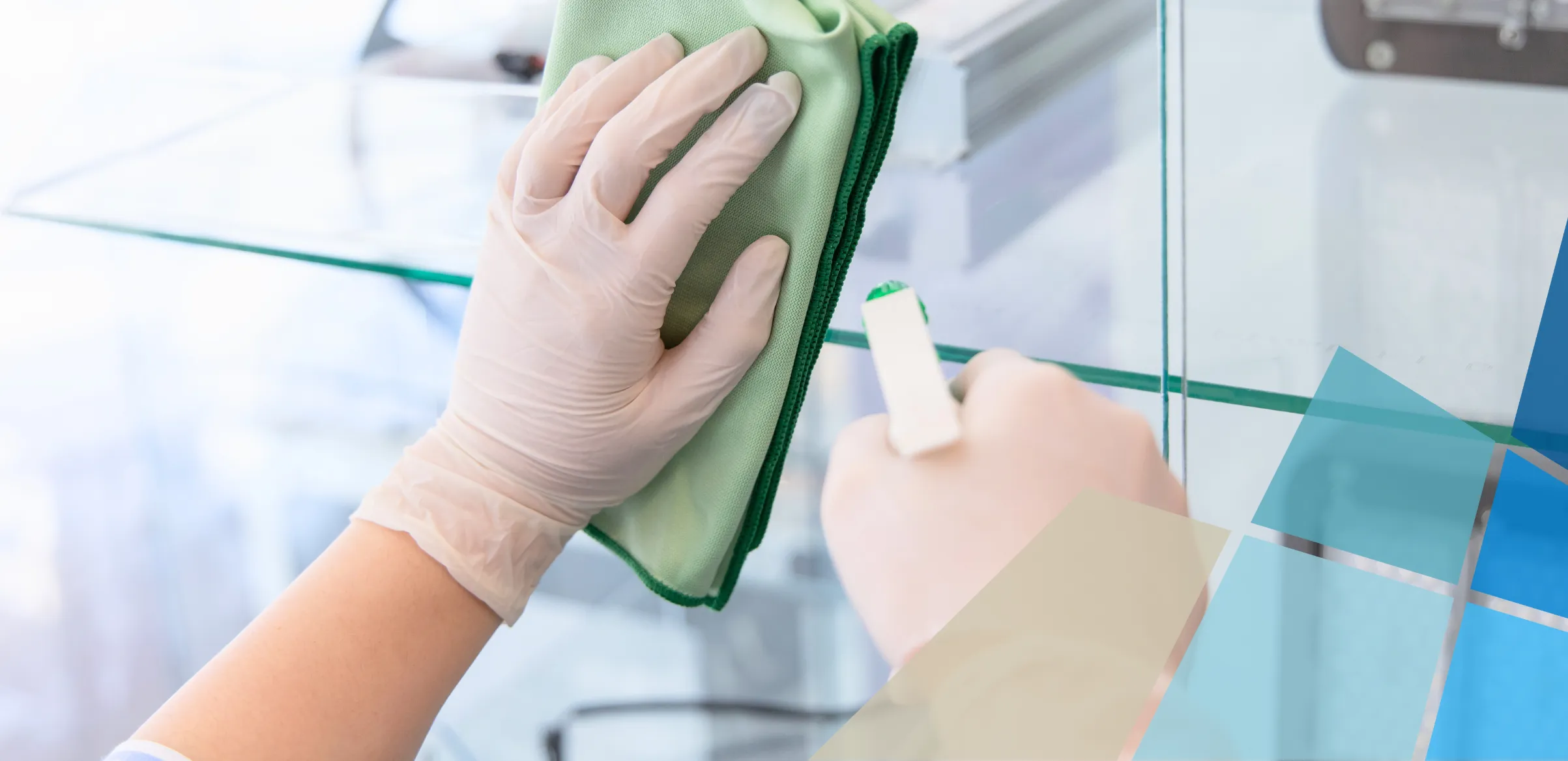 Staff member cleaning office window with spray bottle and cloth